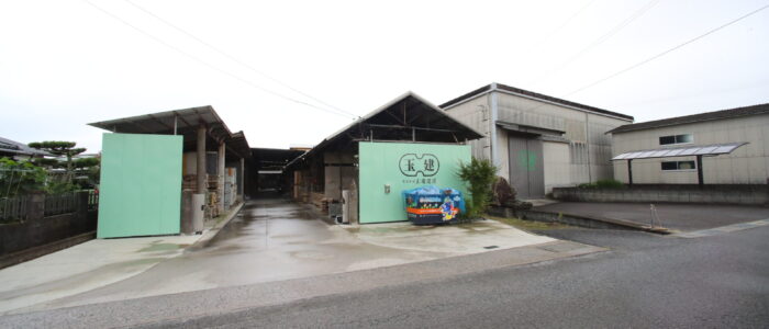 倉庫正面 伊予市下三谷の自社倉庫・加工場。緑の「玉建」ロゴが目印です